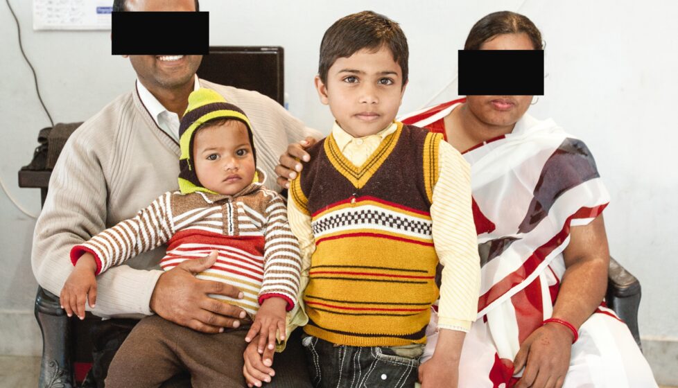 a family of 4 sits on a couch together